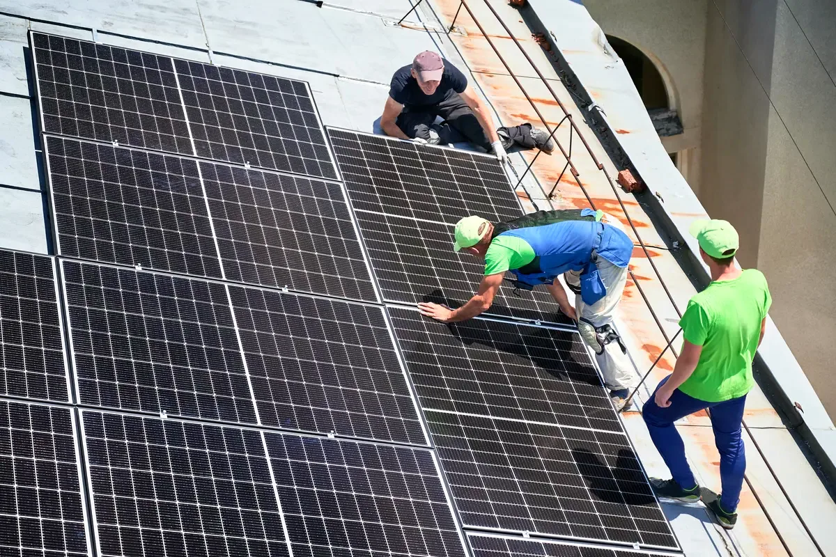 Operarios instalando placas solares en un tejado de Mataró
